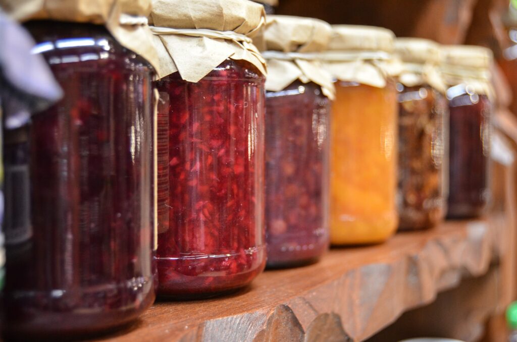 A line of jams in bottles. Hot fill requires the food to be hot when put in the hot jars. 