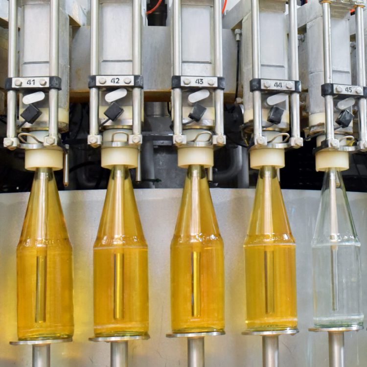 apple juice in glass bottles in a factory for the food industry - bottling and transport